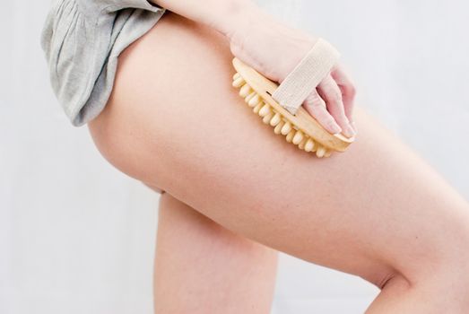 young woman making massage with wooden massager to prevent cellulite