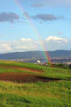 beautiful rainbow photographed from the hills near the city