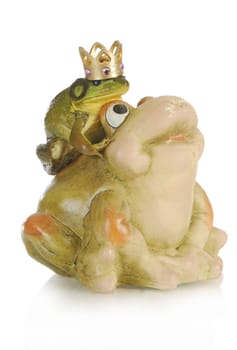 bullfrog sitting on the back of a ceramic frog isolated on white background