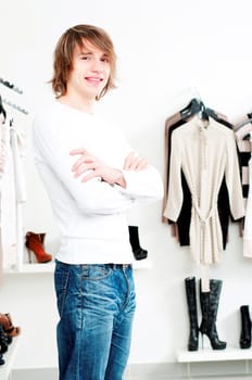 man in shop of clothes, smiles and is happy with purchases