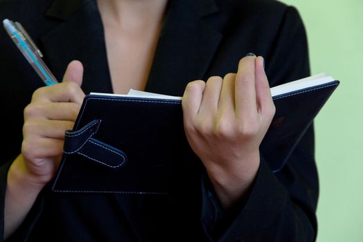 Businesswoman writing in notebook.