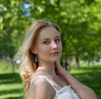 beautiful, young woman standing near the tree in the park