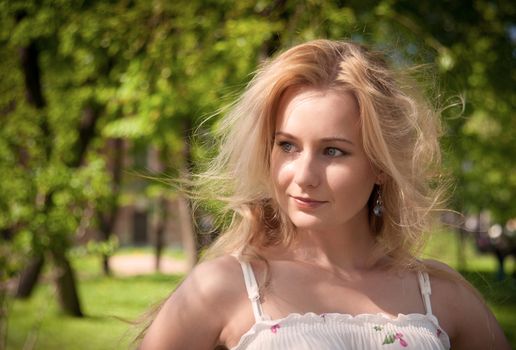 beautiful, young woman standing near the tree in the park