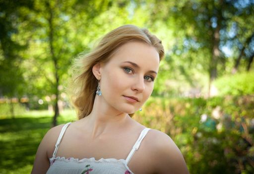 beautiful, young woman standing near the tree in the park