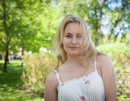 beautiful, young woman standing near the tree in the park