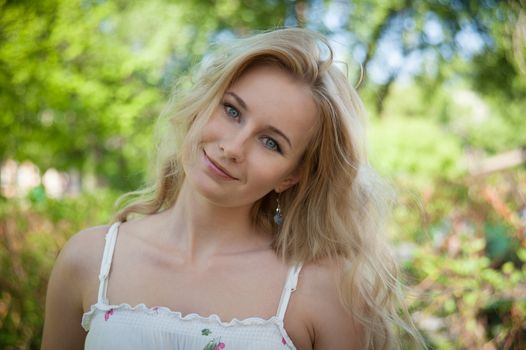 beautiful, young woman standing near the tree in the park