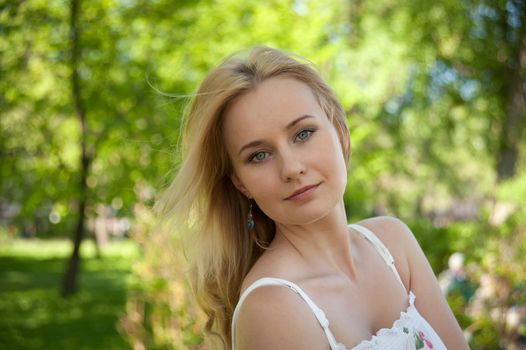 beautiful, young woman standing near the tree in the park