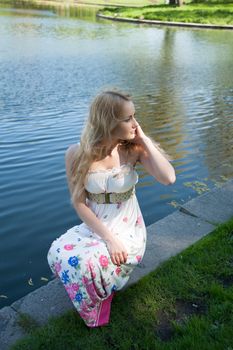beautiful blonde near the water in the summer park