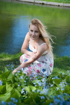 beautiful blonde near the water in the summer park