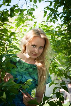 beautiful, young woman standing near the tree in the park