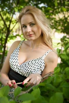 beautiful, young woman standing near the tree in the park