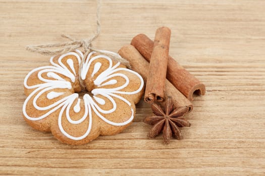 Gingerbread cookies hanging over wooden background with anise and cinamon