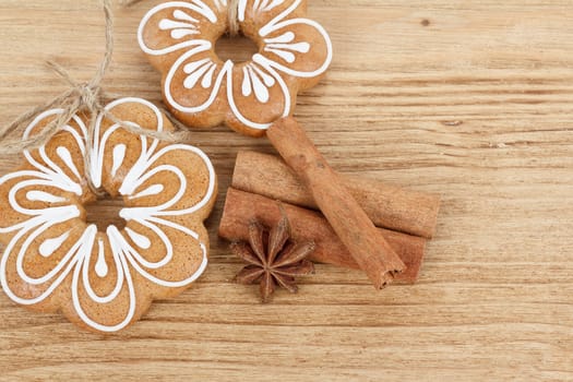 Gingerbread cookies hanging over wooden background with anise and cinamon