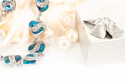 two pearl earrings and sea shells isolated on white