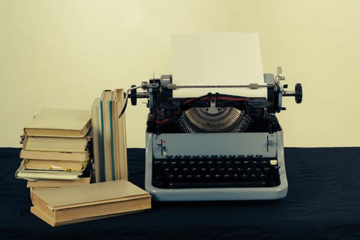 Old typewriter with paper and books, retro colors on the desk