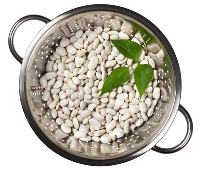 White beans with green leaves in a colander isolated on white background, top view