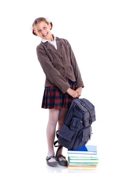 Education theme. Joyful schoolgirl smiling happily with heavy backpack and book. Isolated on white background