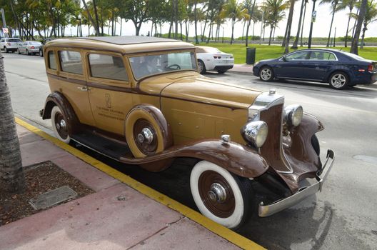 An antique Packard automobile being used to advertise a miami beach hotel parked on ocean drive in miami beach,florida