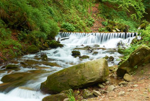 Fast full-flowing mountain river in summer day