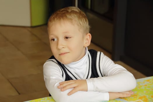 Portrait of sitting boy in white cloth