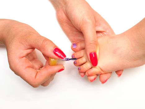 Child pedicure, purple sparkling nailpaint, isolated towards white