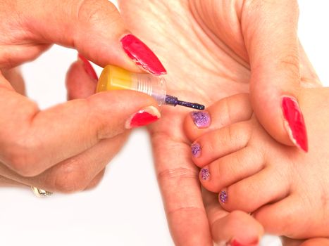 Child pedicure, purple sparkling nailpaint, isolated towards white
