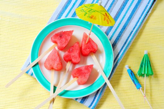 fruit pops of watermelon in heart shaped shoot in studio. watermelon heart as lollipop