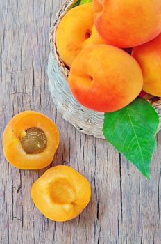 apricot fruits with green leaf and cut isolated on wooden background
