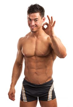 Muscular young man showing the ok sign isolated over white