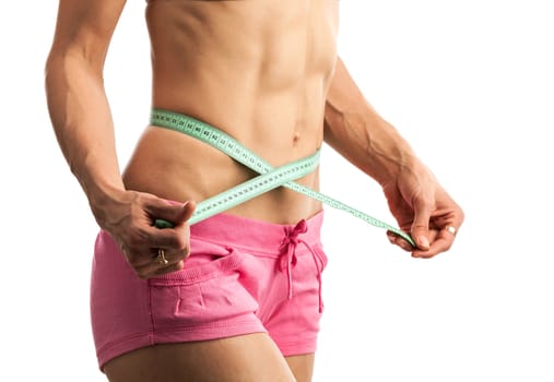 Cropped view of young fitness woman with measuring tape