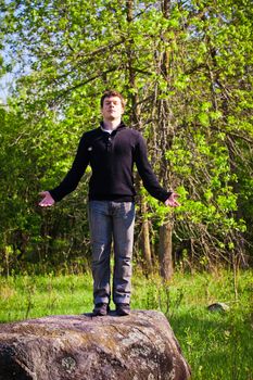 Man standing up on the rock in the forest