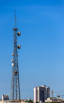 Telecommunication Tower with Antennas in Urban Area, Clear Blue Sky Background
