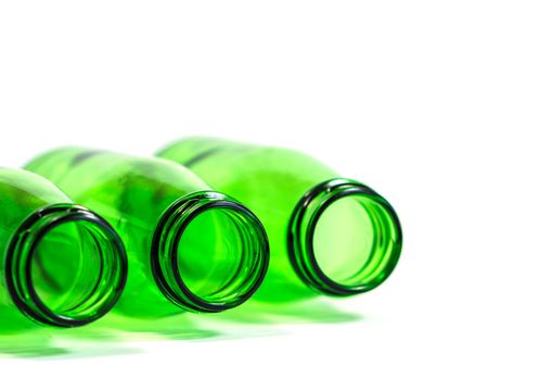 Three Green Bottles Lay Down on White Background with focus on center bottle, Copy Space Above.