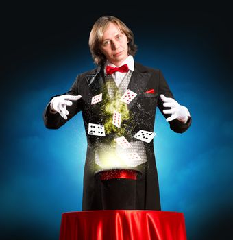 magician casts a spell over the cylinder, around the magic and playing cards