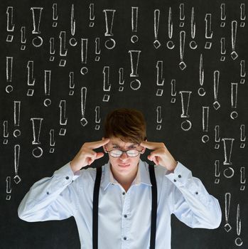 Thinking business man with chalk exclamation marks on blackboard background