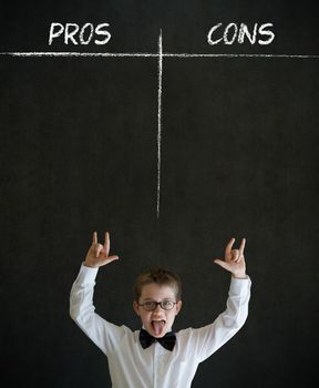 Knowledge rocks boy dressed up as business man with chalk pros and cons decision list on blackboard background