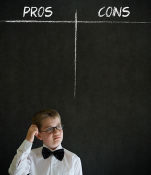 Scratching head thinking boy dressed up as business man with chalk pros and cons decision list on blackboard background