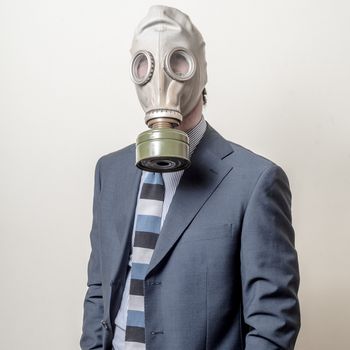 businessman with gas mask on gray background