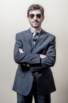 businessman serious with sunglasses on gray background