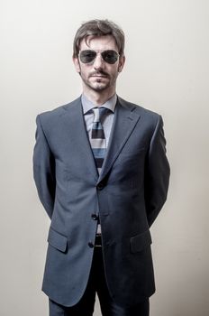 businessman serious with sunglasses on gray background