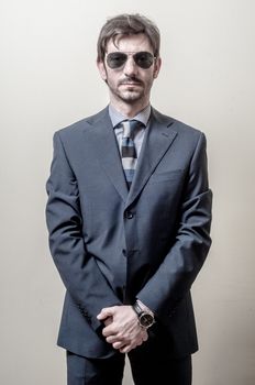 businessman serious with sunglasses on gray background