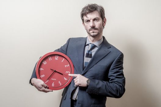 businessman pointing clock on gray background