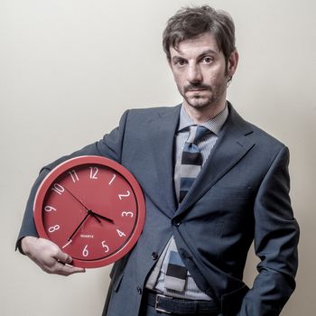 businessman with clock on gray background