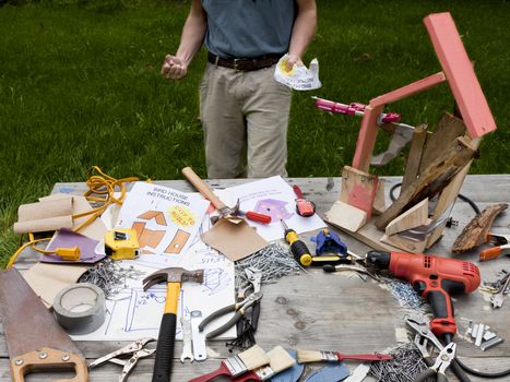 A man is frustrated and angry at building a bad birdhouse.