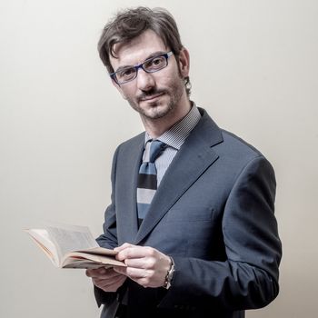 businessman reading book on gray background