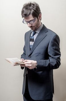 businessman reading book on gray background