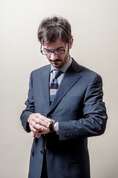 businessman looking wristwatch on gray background