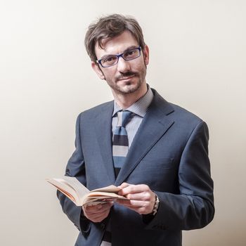 businessman reading book on gray background