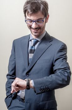 businessman looking wristwatch on gray background