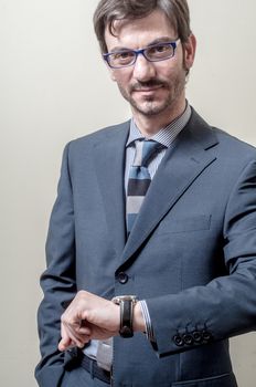businessman looking wristwatch on gray background